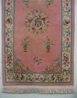 A pink and floral patterned Chinese rug 87" x 49"