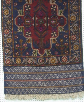 A contemporary blue ground Belouch rug with central medallion within multi row borders 55" x 30"