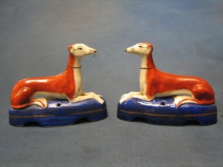 A pair of 19th Century Staffordshire pen rests in the form of seated grey hounds 5"