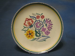 A circular Poole Pottery plate with floral decoration, base with rubber stamp mark 10"