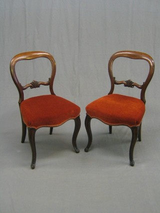 A set of 5 Victorian rosewood spoon back dining chairs with shaped mid rails, the seats of serpentine outline and upholstered in orange coloured Dralon, on French cabriole supports