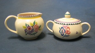 A circular Poole Pottery cream jug with floral decoration 3" and a matching sugar bowl and cover and cover 2"