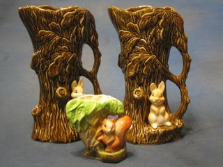 2 Sylvac pottery jugs in the form of tree stumps, bases decorated rabbits 10" and a Hornsea jug in the form of a tree stump decorated a squirrel 4"