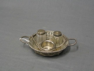 A circular basket work silver plated condiment frame with salt, pepper and mustard pot