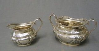 A Victorian embossed silver plated twin handled sugar bowl and matching cream jug
