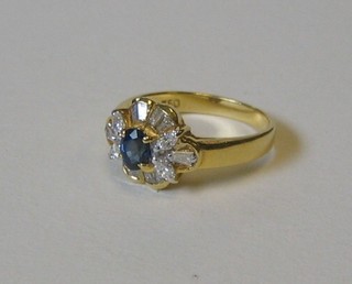 A lady's 18ct gold dress ring set an oval cut sapphire supported by 10 baguette cut diamonds and 4 circular cut diamonds