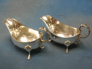 A large pair of Georgian style silver plated sauce boats with armorial decoration and C scroll handles