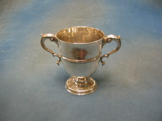 A Georgian Irish silver twin handled cup raised on a circular spreading foot with armorial decoration, marks rubbed, 13 ozs