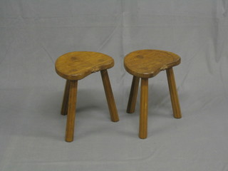 A pair of 20th Century 3 legged, arched shaped stools by Thomas, each carved a mouse