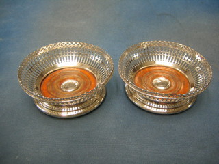 A handsome pair of circular pierced silver plated wine coasters with armorial decoration by Elkingtons