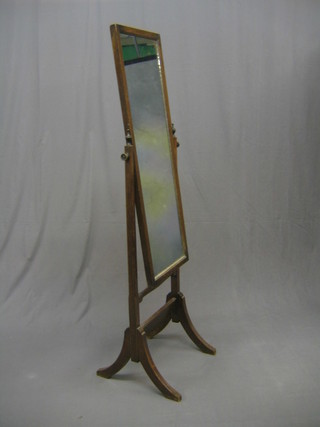A rectangular cheval mirror contained in an oak swing frame