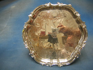 An engraved silver plated salver with bracketed border and armorial decoration, raised on 3 panel supports 12"