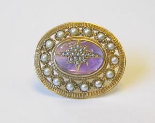 A lady's 9ct gold brooch set a cabouchon cut pink stone supported by numerous diamonds
