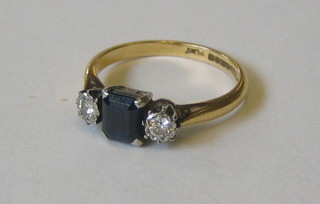 A lady's 18ct gold dress ring set a square cut sapphire supported by 2 diamonds