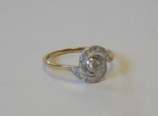 A lady's 18ct gold swirl shaped dress ring with diamond to the centre, surrounded by numerous diamonds