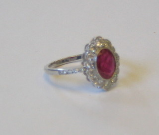 A lady's 18ct white gold dress ring set an oval cut ruby supported by numerous diamonds