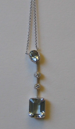 A lady's 18ct white gold chain hung a pendant set an oval cut aquamarine above 2 circular cut diamonds and a square cut aquamarine