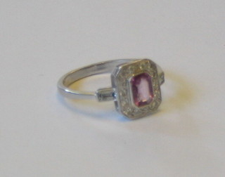 A lady's 18ct white gold dress ring set a rectangular cut pink sapphire surrounded by numerous diamonds and with baguette cut diamonds to the shoulders