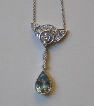 A lady's gold pendant in the form of a key stone set diamonds above a tear drop aquamarine