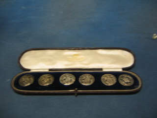 A set of 5 Art Nouveau pierced "silver" buttons decorated a head and shoulders of a girl, the reverse marked 352928 together with a circular pierced silver button decorated a lion mask and contained in a fitted leather case