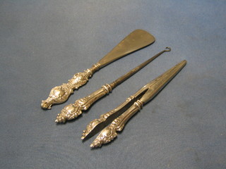 A shoe horn with silver mounts, a pair of glove stretchers and a button hook