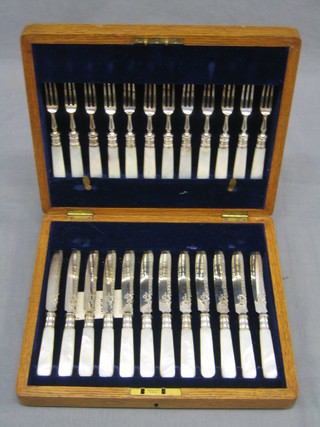 A set of 12 Victorian silver plated fruit knives and forks with mother of pearl handles, contained in an oak canteen box