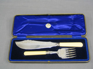 A pair of silver plated fish servers with engraved blades, silver bands and bone handles