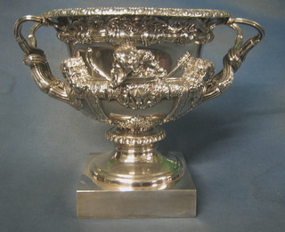 A handsome Victorian embossed silver plated wine cooler with armorial decoration of urn form, cast classical relief and raised on a square base 10"
