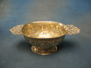 An oval embossed Dutch silver bowl with pierced twin handles, decorated masks and swags, raised on a circular spreading base 7 ozs