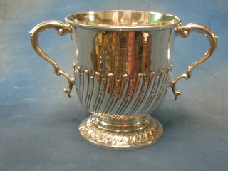A handsome Victorian twin handled cup, engraved The Arms of the Royal Rock Beagles, with demi-reeded decoration, raised on a circular spreading foot, inscribed "Presented to Miss Mabel C Morgan on Her Marriage by a Few of Her Father's Old Comrades on the Royal Rock Beagle Hunt" London 1887, 33 ozs