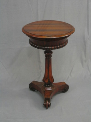 A William IV circular rosewood teapoy with hinged lid fitted 2 caddies (1 hinge f) and 2 mixing bowls, raised on a florette carved column ending in a triform base and scrolled feet 20"