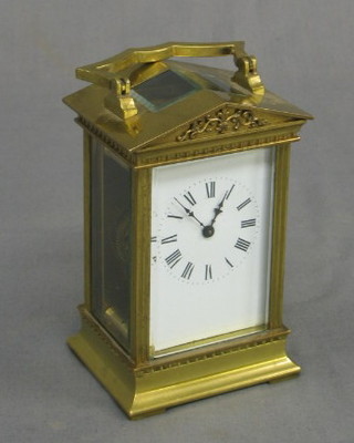 A 19th Century French 8 day carriage clock with porcelain dial and Roman numerals contained in a Portico style gilt metal case