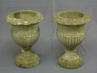 A pair of well weathered 19th Century circular stone urns of trumpet form, the bodies with demi-reeded decoration 17" high, 12" diameter,
