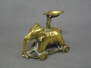 An Eastern brass figure of an elephant raised on a trunion 8"