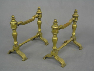 A pair of brass fire dogs