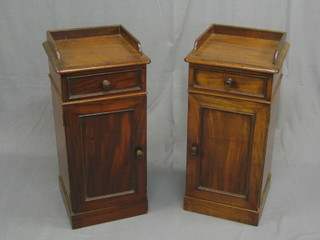 A pair of Victorian mahogany pedestal bedside cabinets with three-quarter galleries, each fitted a drawer above a cupboard, raised on a platform base 14"
