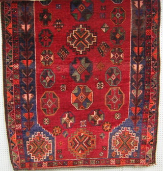 A contemporary red ground Persian carpet with octagons to the centre 84" x 53"