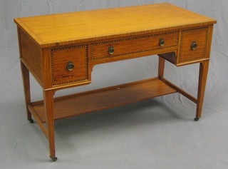 An Edwardian  satinwood writing table with crossbanded top inlaid ebony stringing, fitted 1 long drawer flanked by 2 short drawers raised on square tapering supports united by an H framed stretcher 48"