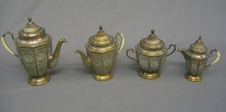 A 4 piece Eastern embossed metal tea/coffee service comprising teapot, coffee pot, twin handled sugar bowl and cover and cream jug