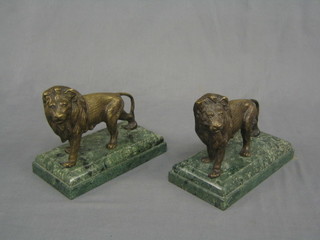 A pair of reproduction bronze book ends raised on green marble bases