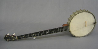 A 4 stringed banjo with 11" circular open back drum, by J E Dallas
