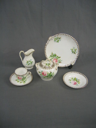 A floral pattern tea service with rose deocration, comprising 2 twin handled bread plates, lidded sucrier, cream jug, 11 tea plates (2 cracked), 12 saucers (1 cracked) 5 cups (1 cracked), some rubbing to banding