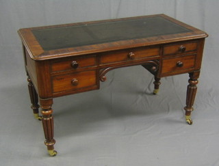 A William IV rectangular mahogany writing table with inset tooled leather writing surface, above 1 long and 4 short drawers, raised on turned and reeded supports ending in brass caps and castors