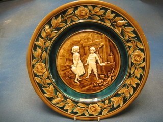 A circular Austrian pottery plate decorated boy and girl, the reverse impressed Made in Austria 545 12"