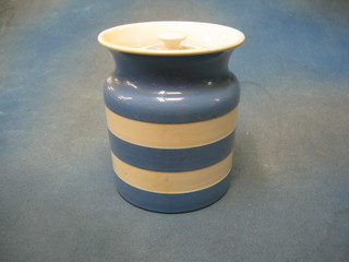 A circular T G Greener blue and white striped Cornish kitchenware storage jar and cover with green shield mark to base 7"
