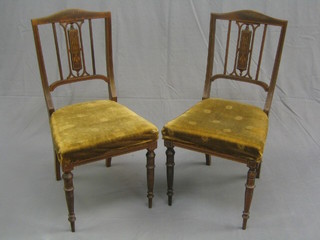 A pair of Edwardian inlaid mahogany stick and rail back bedroom chairs with upholstered seats on turned supports