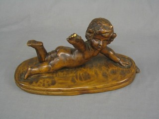 A 19th Century carved wooden figure of a reclining cherub raised on an oval cushion (3 figures and thumb f, old repair to arm, some worm) 16"