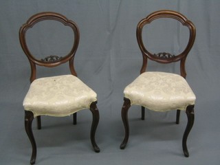A set of 6 Victorian carved walnut balloon back dining chairs with pierced mid rails, the seats of serpentine outline, raised on French cabriole supports (1f and r)