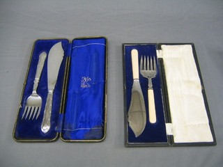 A pair of silver plated fish servers with ribbon ware handles, cased
