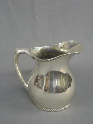A large silver plated jug with rope edge border 9"